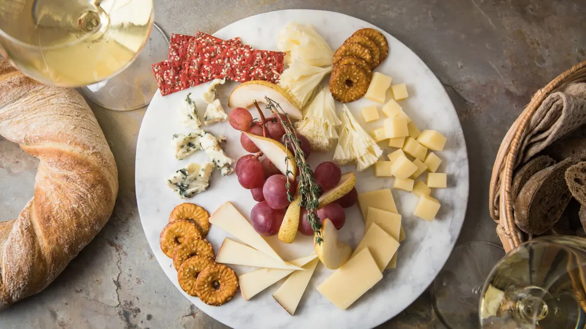 Käsebrett Schweizer Käse: ILLUSTRATION - Eine Käseplatte nach der Uhr gestellt: Um 12 Uhr beginnt es mild mit Tête de Moine, wird mit Emmentaler, Le Gruyere und Appenzeller immer herzhafter und schließt zwischen 9 und 11 Uhr mit würzigem Blauschimmelkäse. Trauben, Birnenspalten, Thymian, Rote-Bete- und Brezel-Chips lockern die Platte auf. (zu dpa: «Wie ein Schweizer Uhrwerk: So wird die Käseplatte perfekt») Foto: Christin Klose/dpa-mag - Honorarfrei nur für Bezieher des Dienstes dpa-Magazin +++ dpa-Magazin +++