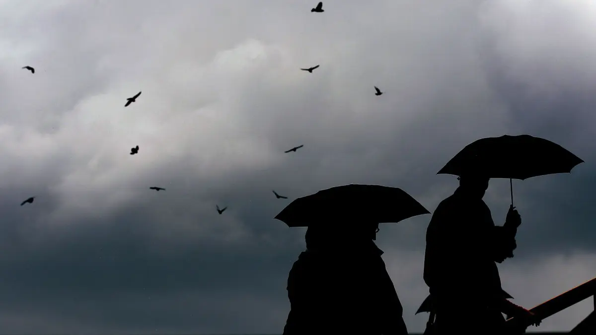 Unbeständiges Wetter: ARCHIV - 23.06.2011, Nordrhein-Westfalen, Köln: Passanten gehen mit Regenschirmen durch eine Stadt. (zu dpa: «Es wird kalt in NRW mit Regen und Wind - Schnee möglich») Foto: Oliver Berg/dpa +++ dpa-Bildfunk +++