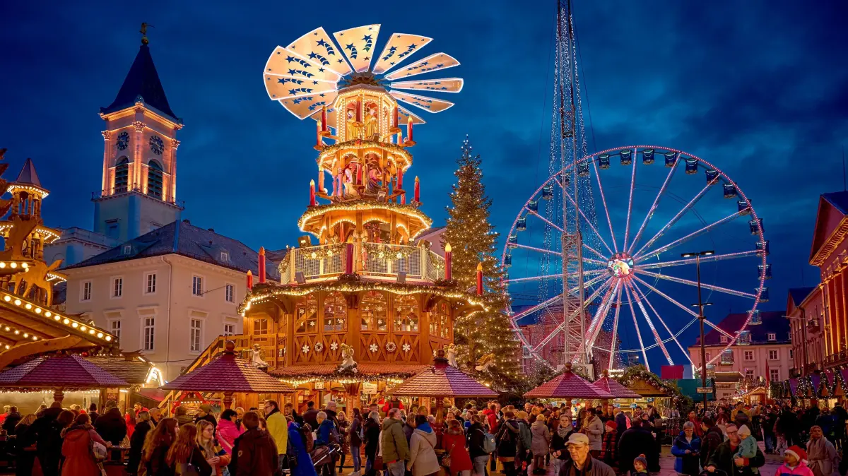 Das Riesenrad ist ein echter Hingucker auf dem Christkindlesmarkt in Karlsruhe. Prominent im Bild, schön beleuchtet, ist die Glühweinpyramide zu sehen.