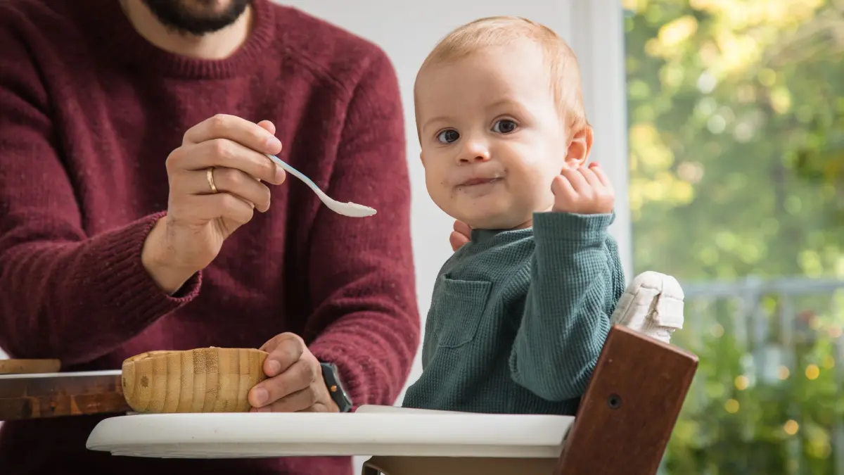 Mann füttert Kleinkind in einem Hochstuhl: ILLUSTRATION - Sicher und bequem soll ein Kinderhochstuhl sein. Die Stiftung Warentest hat zwölf Modelle von verschiedenen Anbietern getestet. (zu dpa: «Kinderhochstühle im Test: Nur drei Modelle sind «gut»») Foto: Christin Klose/dpa-mag - ACHTUNG: Nur zur redaktionellen Verwendung im Zusammenhang mit dem genannten Text - Honorarfrei nur für Bezieher des Dienstes dpa-Magazin +++ dpa-Magazin +++