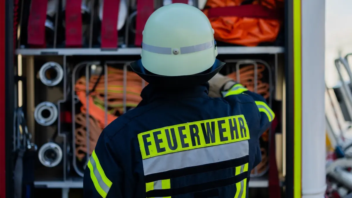 ARCHIV - 11.01.2024, Nordrhein-Westfalen, Leverkusen: Ein Feuerwehrmann holt Equipment aus einem Einsatzfahrzeug an der Feuerwache der Feuerwehr (Illustration) (zu dpa: «Alarm wegen Kohlenmonoxid in Parkhaus») Foto: Rolf Vennenbernd/dpa +++ dpa-Bildfunk +++