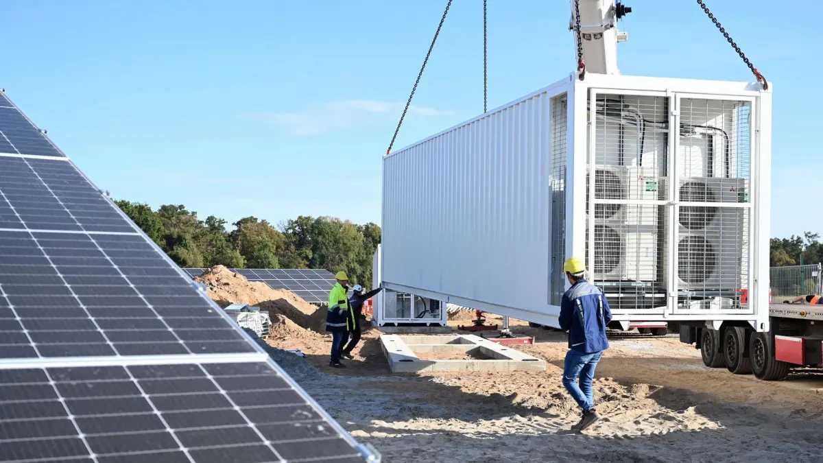 13.10.2023, Baden-Württemberg, Bruchsal: An einem fast fertigen Solarpark des Energieversorgers EnBW wird ein Batteriespeicher angeliefert. Insgesamt wurden dort zwei aufgestellt. EnBW will künftig grundsätzlich Batteriespeicher in neu geplante Solarparks einbauen. Damit setzt der Konzern eigenen Worten zufolge als erstes Energieunternehmen in Deutschland standardmäßig auf solche Speicher in Solarparks. Foto: Uli Deck/dpa +++ dpa-Bildfunk +++