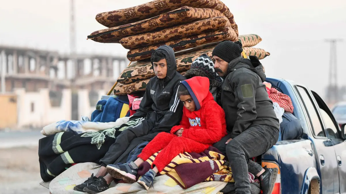 Displaced Syrian Kurds drive vehicles loaded with belongings on the Aleppo-Raqqa highway to flee areas on the outskirts of the northern city of Aleppo which were formerly controlled by the Kurdish-led Syrian Democratic Forces (SDF), after they were seized by Islamist-led rebels on December 2, 2024. On November 27, the Islamist Hayat Tahrir al-Sham (HTS) alliance, led by Al-Qaeda's former Syria branch launched a major offensive snatching Syria's second city Aleppo and dozens of towns and villages from government control, after years of regime gains in successive Russian-backed military campaigns. (Photo by Rami al SAYED / AFP)
