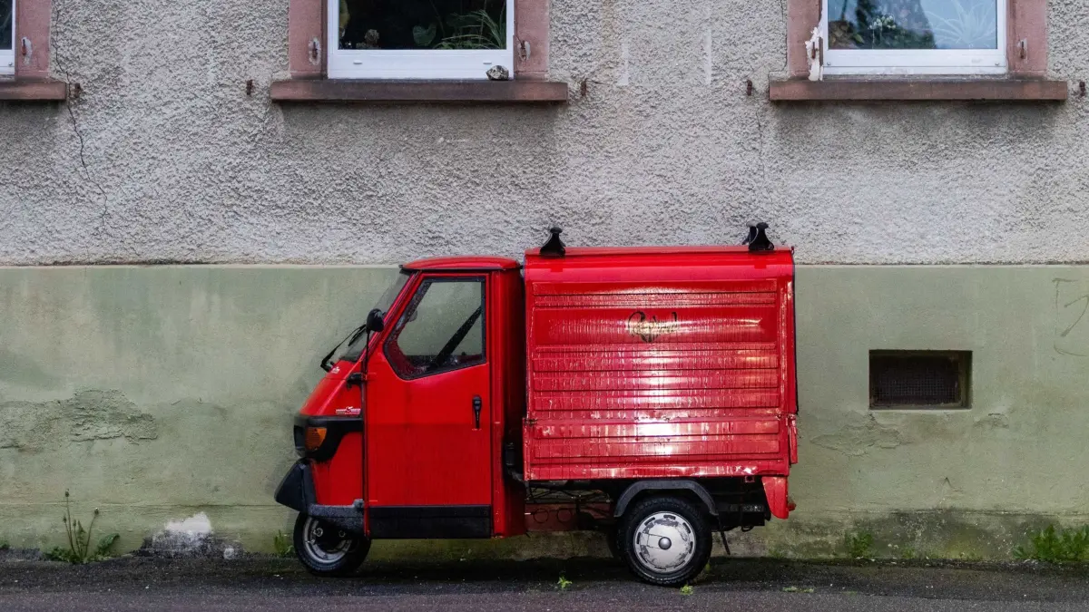 ARCHIV - 28.04.2023, Baden-Württemberg, Freiburg: Eine rote Piaggio "Ape" steht vor einem Haus. (zu dpa: «Italien nimmt Abschied von der «Biene»») Foto: Philipp von Ditfurth/dpa +++ dpa-Bildfunk +++