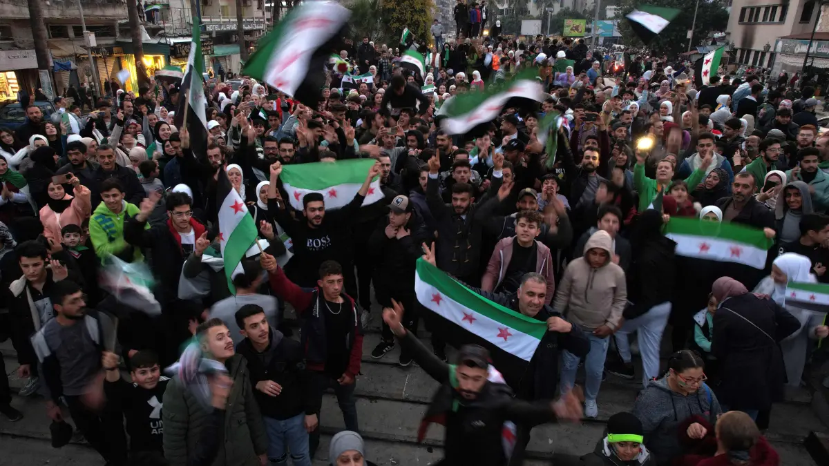 An aerial picture shows people gathering to celebrate in Syria's western port city of Latakia on December 11, 2024. Islamist-led rebels took Damascus in a lightning offensive on December 8, ousting president Bashar al-Assad and ending five decades of Baath rule in Syria. (Photo by Aaref WATAD / AFP)