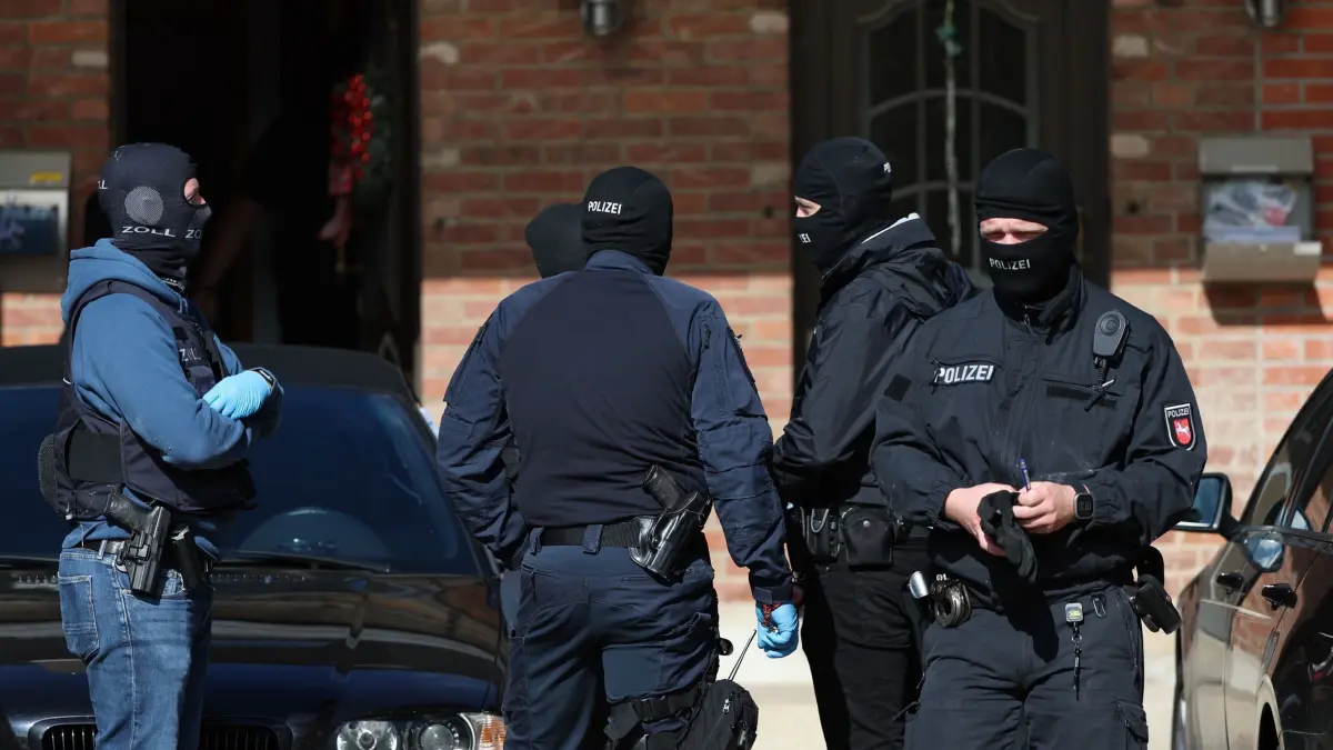 Razzia gegen mutmaßliche Reichsbürger: ARCHIV - 13.06.2024, Niedersachsen, Melle: Polizisten stehen bei einer Razzia vor einem Haus. Die Zahl extremistischer Straftaten hat stark zugenommen. (zu dpa: «Politisch motivierte Kriminalität stark gestiegen») Foto: Friso Gentsch/dpa +++ dpa-Bildfunk +++