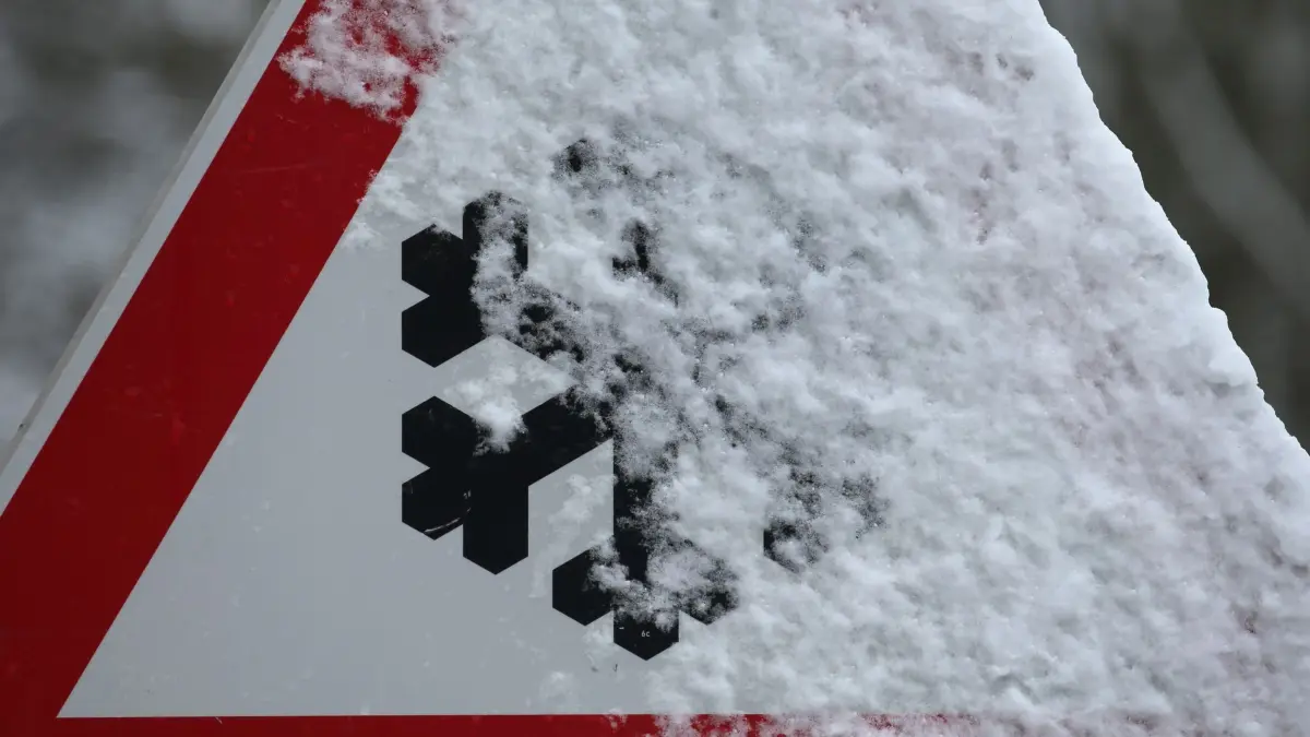Neuschnee im Süden: ARCHIV - 29.01.2020, Bayern, Stötten: Schneebedeckt ist ein Warnschild das auf Schneeglätte hinweist. (zu dpa: «Schneefall sorgt für Behinderungen und Unfälle im Saarland») Foto: Karl-Josef Hildenbrand/dpa +++ dpa-Bildfunk +++