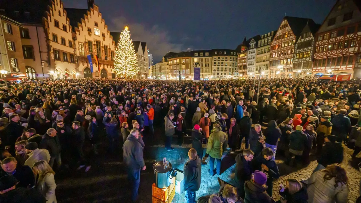 Das Große Stadtgeläute von Frankfurt am Main am Heiligabend: 24.12.2024, Hessen, Frankfurt/Main: Menschen sind auf dem Römerberg zum „Großen Stadtgeläute“ zusammengekommen. Auch Glühwein wird angeboten. An Heiligabend hat das Große Stadtgeläute, mit 50 Glocken von zehn Innenstadtkirchen, viele tausend Menschen in die Innenstadt gelockt. Foto: Andreas Arnold/dpa +++ dpa-Bildfunk +++