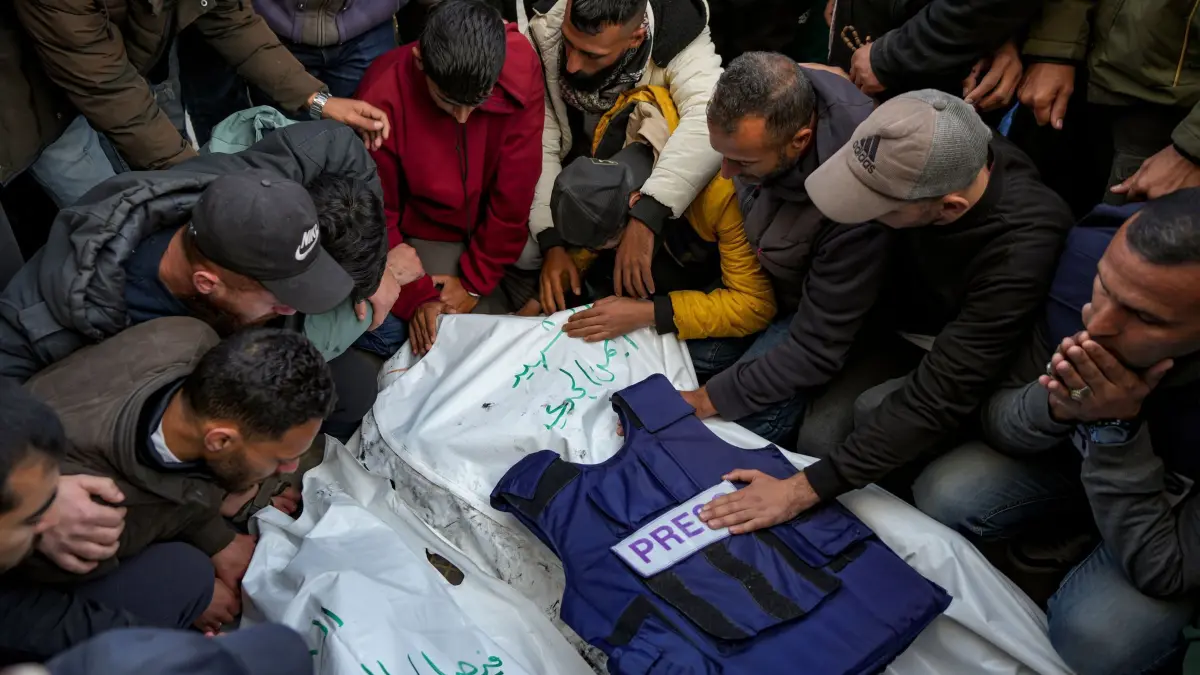 Nahostkonflikt - Gazastreifen: 26.12.2024, Palästinensische Gebiete, Deir al-Balah: Angehörige und Freunde trauern um die Leichen von fünf palästinensischen Journalisten, die bei einem israelischen Luftangriff in Gaza-Stadt getötet wurden. Bei einem israelischen Luftangriff im Gazastreifen sind nach unbestätigten Medienberichten fünf palästinensische Journalisten getötet worden. Foto: Abdel Kareem Hana/AP/dpa +++ dpa-Bildfunk +++