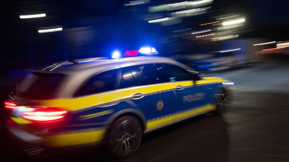 Illustration - Polizei: ILLUSTRATION - 30.11.2023, Baden-Württemberg, Stuttgart: Ein Polizeifahrzeug fährt im Rahmen eines Fototermins mit Blaulicht an einem Gebäude vorbei (gestellte Szene, Langzeitblichtung mit Wischeffekt). (zu dpa: «Feuerwerk auf Autos und Passanten geworfen») Foto: Marijan Murat/dpa +++ dpa-Bildfunk +++