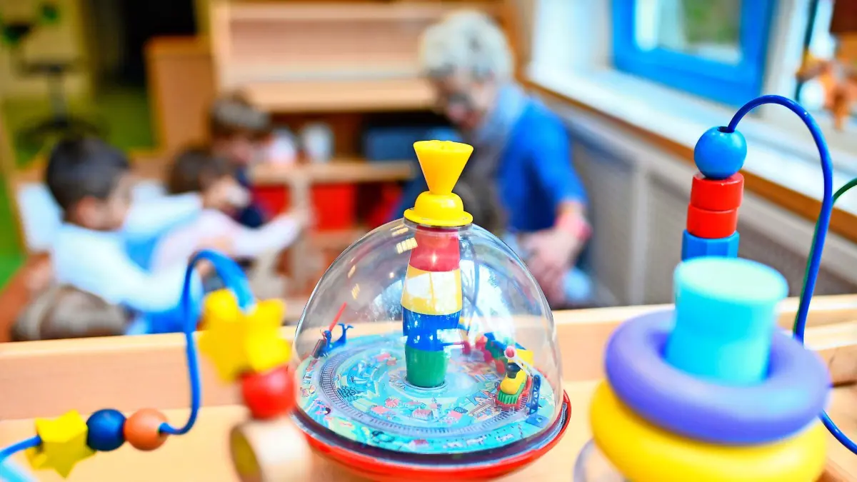 ARCHIV - 20.10.2017, Baden-Württemberg, Mannheim: Eine Erzieherin spielt in einer Kita mit Kindern. Im Vordergrund steht Spielzeug. (zu dpa: «Ministerium sieht «Direkteinstieg Kita» als Erfolg gegen Personalmangel») Foto: Uwe Anspach/dpa +++ dpa-Bildfunk +++