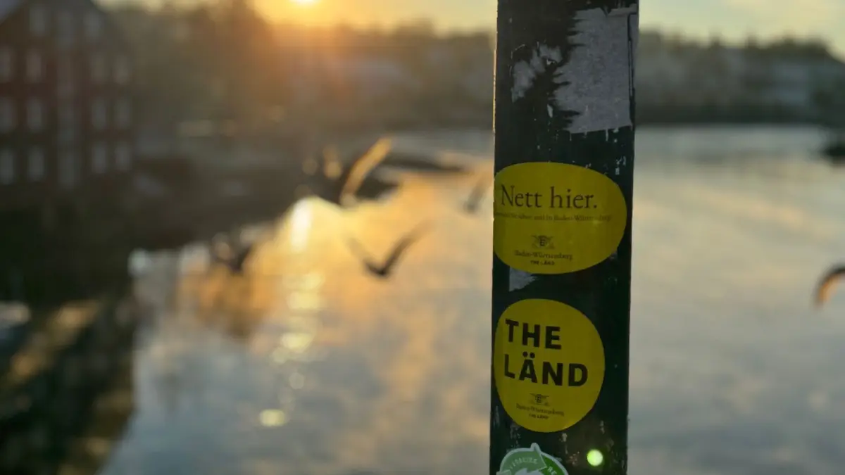 Kampagne „The Länd“: ARCHIV - 21.11.2023, Norwegen, Trodheim: An einem Pfahl auf einer Brücke kleben Aufkleber mit der Aufschrift "Nett hier" und "The Länd". Die Sticker sind Teil der Kampagne "The Länd" des Landes Baden-Württemberg. (zu dpa: ««Nett hier» - Aber warum sind die Sticker so ein Erfolg?») Foto: Valentin Gensch/dpa +++ dpa-Bildfunk +++