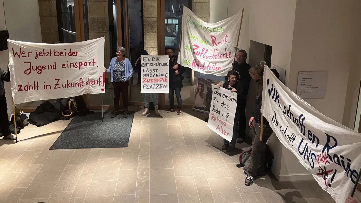 Vor dem Ratsaal im Tübinger Rathaus protestieren verschiedene Organisationen gegen Kürzungen im sozialen Bereich.