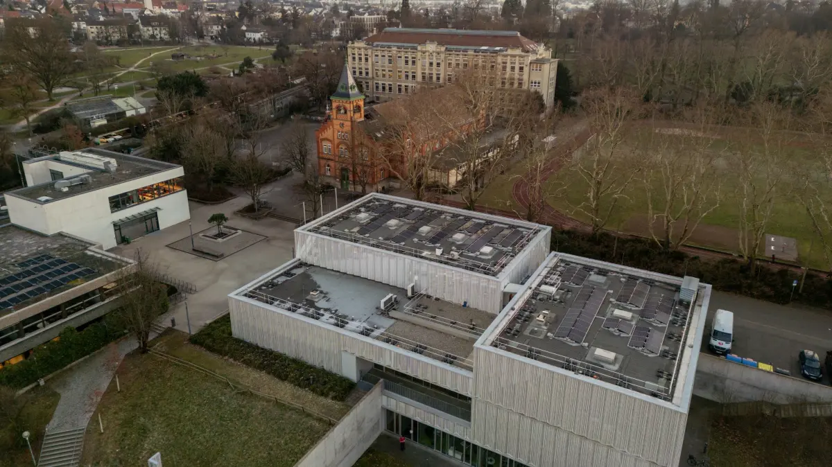 Photovoltaik-Anlagen auf städtischen Dächern: Auf dem Tonne-Theater (vorne) wird schon Strom erzeugt, auf der Jahnhalle (Mitte) soll dieses Jahr eine Anlage installiert werden.