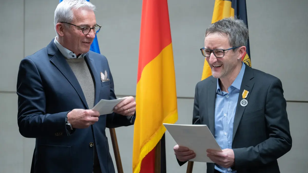 Innenminister Strobl verleiht Rettungsmedaille des Landes: PRODUKTION - 20.01.2025, Baden-Württemberg, Stuttgart: Innenminister Thomas Strobl (CDU, l) überreichte die Rettungsmedaille und Urkunde im Innenministerium an Tobias Schneller, einem 53-jährigen Lehrer. Tobias Schneller hatte im April 2024 nach einer Messerattacke auf ein vierjähriges Mädchen in einem Supermarkt in Wangen im Allgäu den Täter entwaffnet, verfolgt und die Polizei alarmiert. (zu dpa: «Helfer nach Messerangriff in Supermarkt ausgezeichnet») Foto: Helena Dolderer/dpa +++ dpa-Bildfunk +++