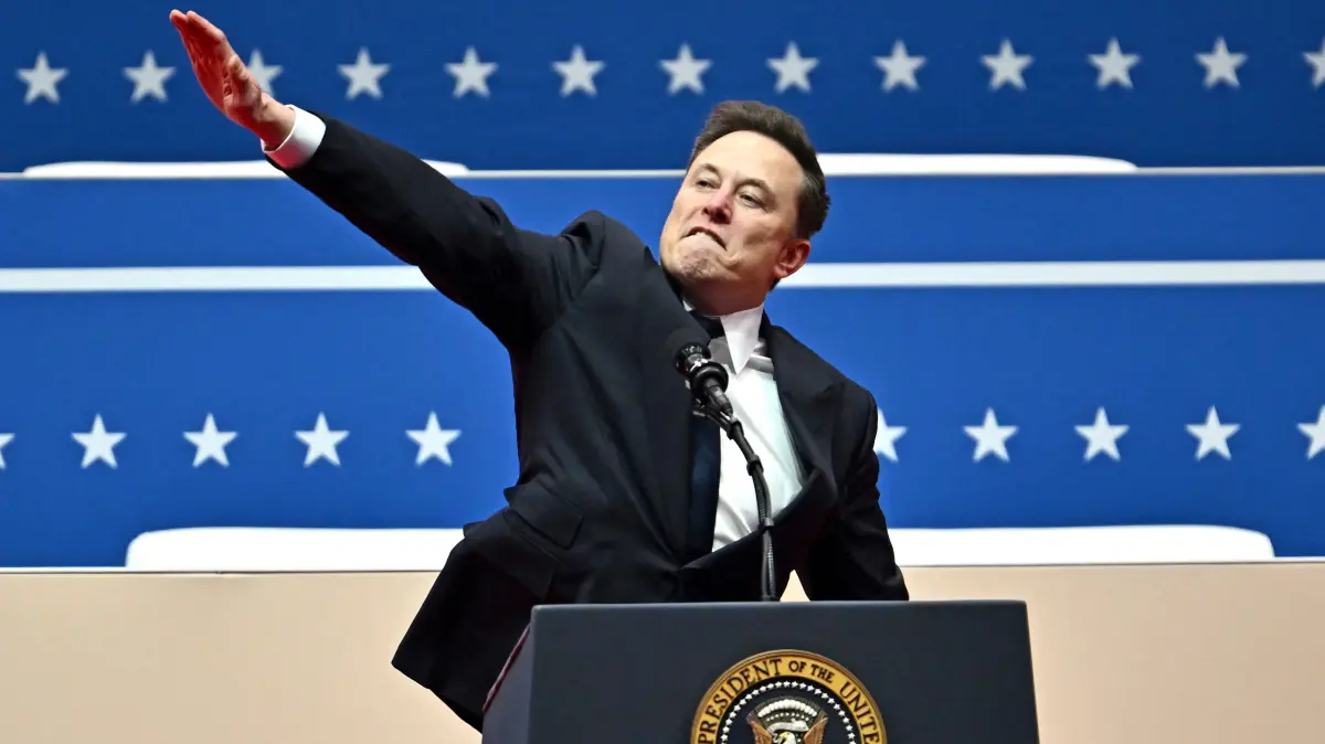 (FILES) Tesla and SpaceX CEO Elon Musk gestures as he speaks during the inaugural parade inside Capitol One Arena, in Washington, DC, on January 20, 2025. Musk's hand gestures at an inauguration event for US President Donald Trump, which quickly drew comparisons to Nazi salutes, appear to have resonated in some far-right extremist spaces online. Several neo-Nazi leaders have shared clips of the viral moment from Musk's Monday speech, in which the billionaire brought his hand to his chest and extended it straight out, twice, before saying: "My heart goes out to you." (Photo by ANGELA WEISS / AFP)