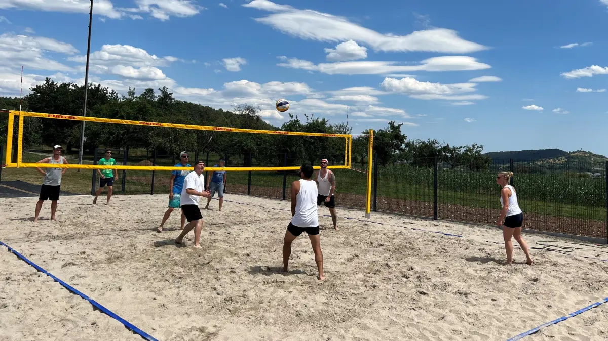 (ohne Überschrift): Vorsicht: Dieses Foto ist möglicherweise nur für den einstigen Verlag Schwäbisches Tagblatt verwendbar. Ein Beachvolleyballfeld haben Wendelsheimer mit ehrenamtlichem Arbeitseinsatz hinter der Turnhalle selbst gebaut - Blick auf die Wurmlinger Kapelle inklusive. Am Samstag eröffneten Ortsvorsteher Joachim Maul und Baubürgermeister Thomas Weigel das von der Ballsportgruppe des Sportvereins initiierte Bürgerprojekt und eine eine neue Weitsprunganlage. Volleyballer des Turnvereins Rottenburg testeten das Sandfeld mit gekonnten Aufschlägen und Schmetterbällen ebenso wie nachmittags Hobbymannschaften bei einem kleinen Turnier (im Bild). Es gab Tanzaufführungen von Kindern, Speisen, kühle Getränke und abends eine Beachbar. Beim Bau mitgeholfen haben neben dem Sportverein der Familienverein, der Grundschulförderverein und der Jugendverein. „Nach der neuen Mehrzweckhalle und dem Kunstrasenplatz verbessert das unsere sportliche Infrastruktur in Wendelsheim weiter“, sagte Maul. Erheblich zur Finanzierung der Kosten von 35.000 Euro trugen neben Zuschüssen der Stadt zu den Materialkosten (11.000 Euro) und des WLSB (7.000 Euro), 5.000 Euro Bürgergeld und viele private Spenden bei. Bild: Andreas Straub