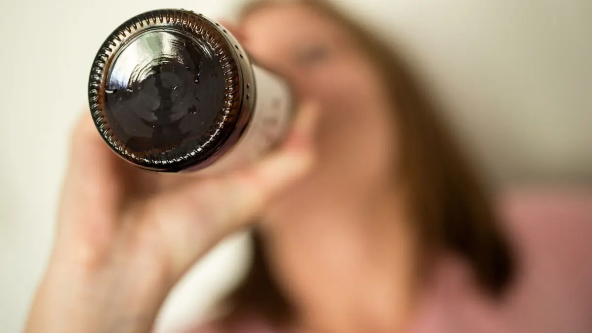 Frau trinkt aus Bierflasche: ILLUSTRATION - Ein Bier oder ein Wein zum Feierabend - oder auch zwei, drei: Frauen trinken zunehmend wie Männer. Zum Teil mit den gleichen, aber auch mit spezifischen Risiken für die körperliche und seelische Gesundheit. (zu dpa: «Alkohol: Was Frauen über die Gefahren wissen sollten») Foto: Alexander Heinl/dpa/dpa-mag - Honorarfrei nur für Bezieher des Dienstes dpa-Magazin +++ dpa-Magazin +++