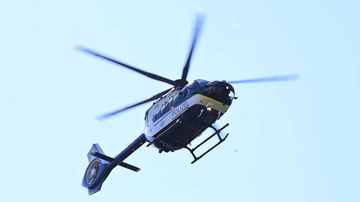 ARCHIV - 22.08.2023, Bayern, München: Ein Helikopter vom Typ Airbus H145 fliegt bei der Vorstellung eines neuen Polizeihubschraubers vom Gelände der I. Bereitschaftspolizeiabteilung ab. (zu dpa: «Polizei sucht flüchtigen Angreifer mit Hubschrauber») Foto: Felix Hörhager/dpa +++ dpa-Bildfunk +++