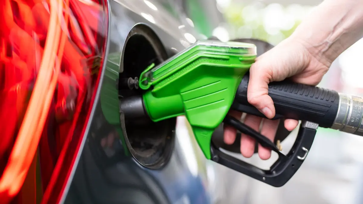 ARCHIV - 06.09.2020, Bayern, München: Eine Frau hält an einer Tankstelle an einer Zapfsäule eine Zapfpistole in der Hand und betankt ein Auto. (zu dpa: «Mehr Diesel und Benziner · weniger Elektroautos») Foto: Sven Hoppe/dpa +++ dpa-Bildfunk +++