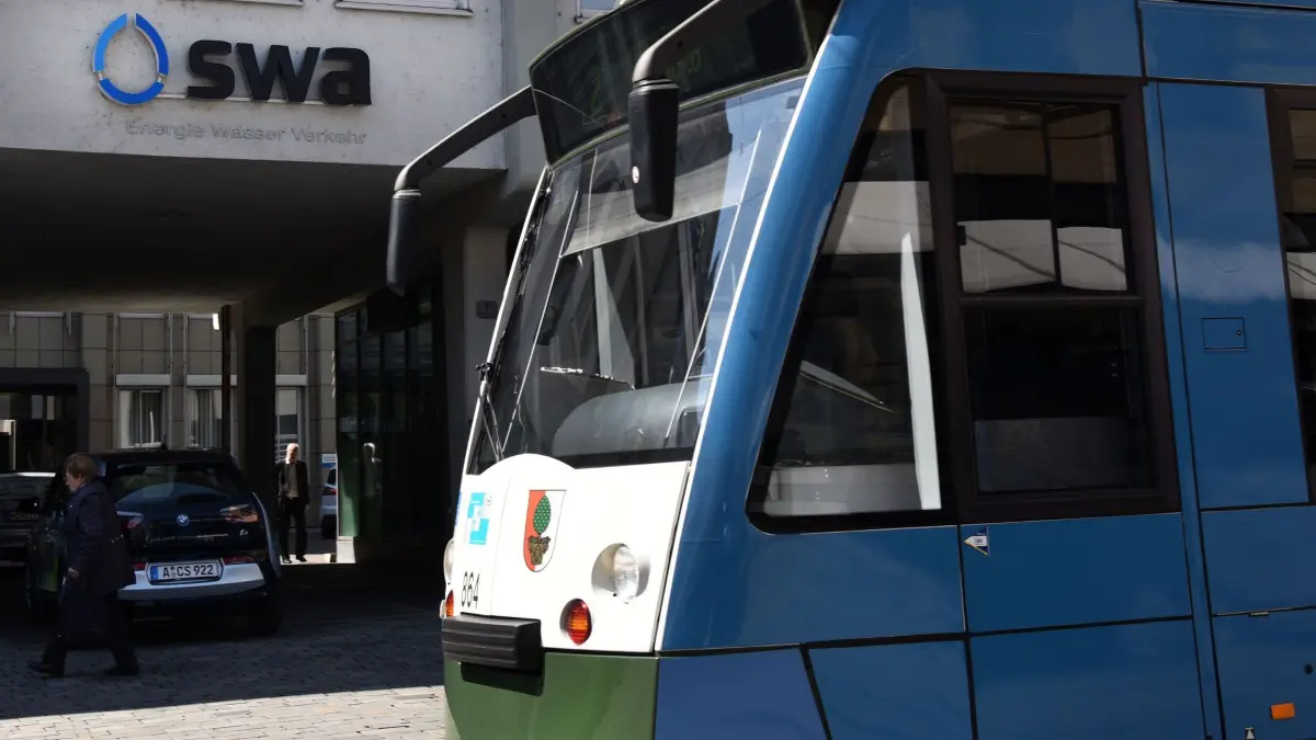 Prozess um Bürgerbegehren zu Stadtwerke Augsburg: ARCHIV - 19.04.2015, Bayern, Augsburg: Vor der Zentrale der Stadtwerke in Augsburg (Bayern) steht eine Straßenbahn. (zu dpa: «Jugendliche fahren außen an Straßenbahn mit») Foto: Stefan Puchner/dpa +++ dpa-Bildfunk +++