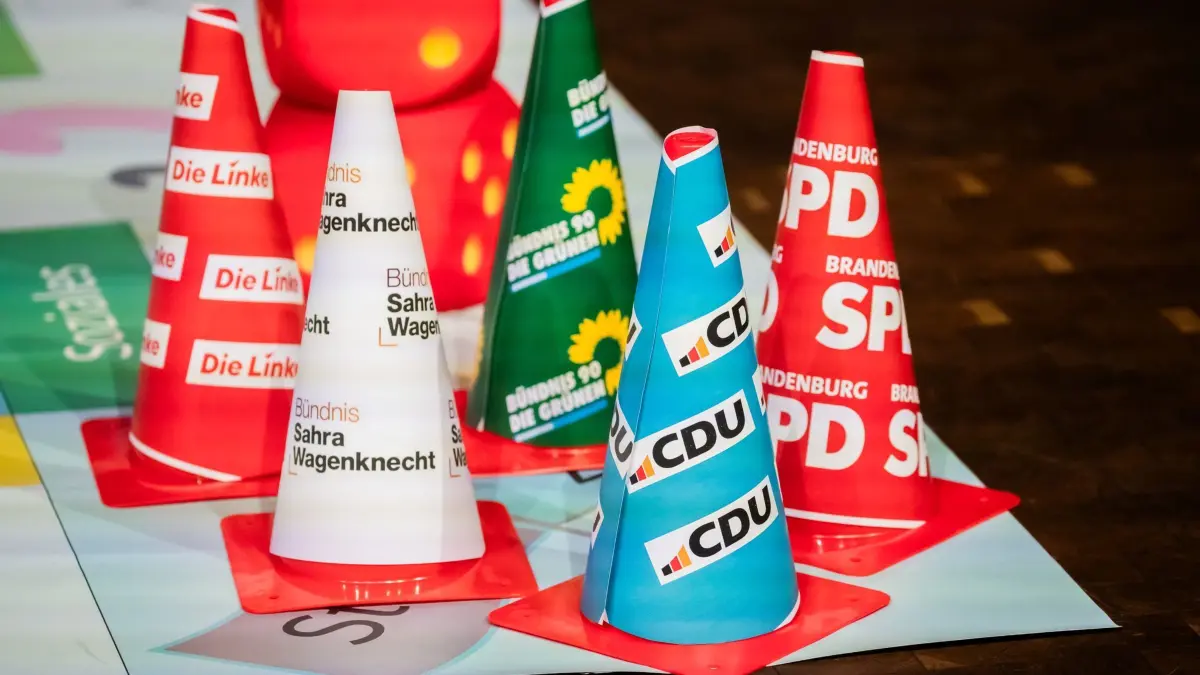 Wahlarena des DGB: 08.02.2025, Brandenburg, Potsdam: Hütchen von CDU, SPD, Grüne, BSW und Die Linke stehen vor Beginn der Wahlarena des Deutschen Gewerkschaftsbunds (DGB) zu den Themen gute Arbeit, starke Wirtschaft und soziale Sicherheit in der Potsdamer Schinkelhalle auf einer Spielfläche. Foto: Christoph Soeder/dpa +++ dpa-Bildfunk +++