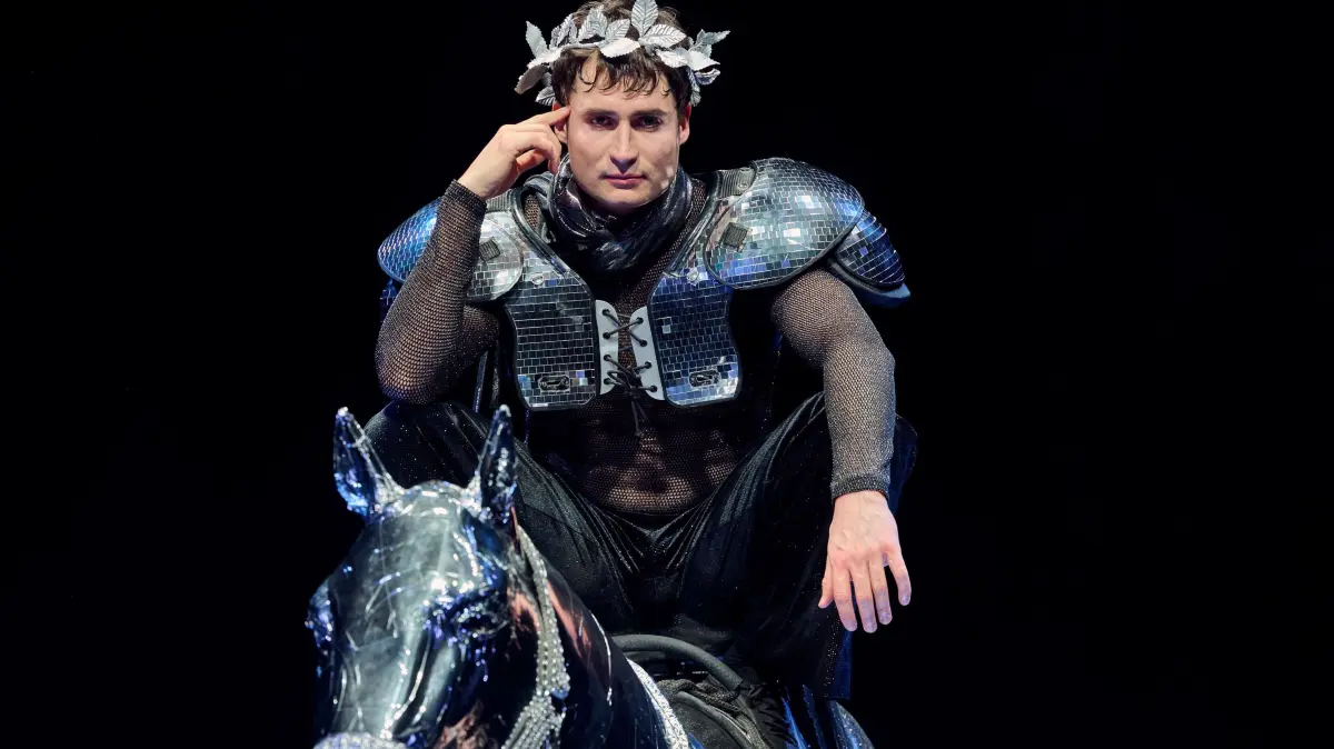 Caligula (Jonas Hellenkemper) als Lorbeer-bekränzte Venus, Caesonia (Rosalba Salomon) hält ihm die Zügel.