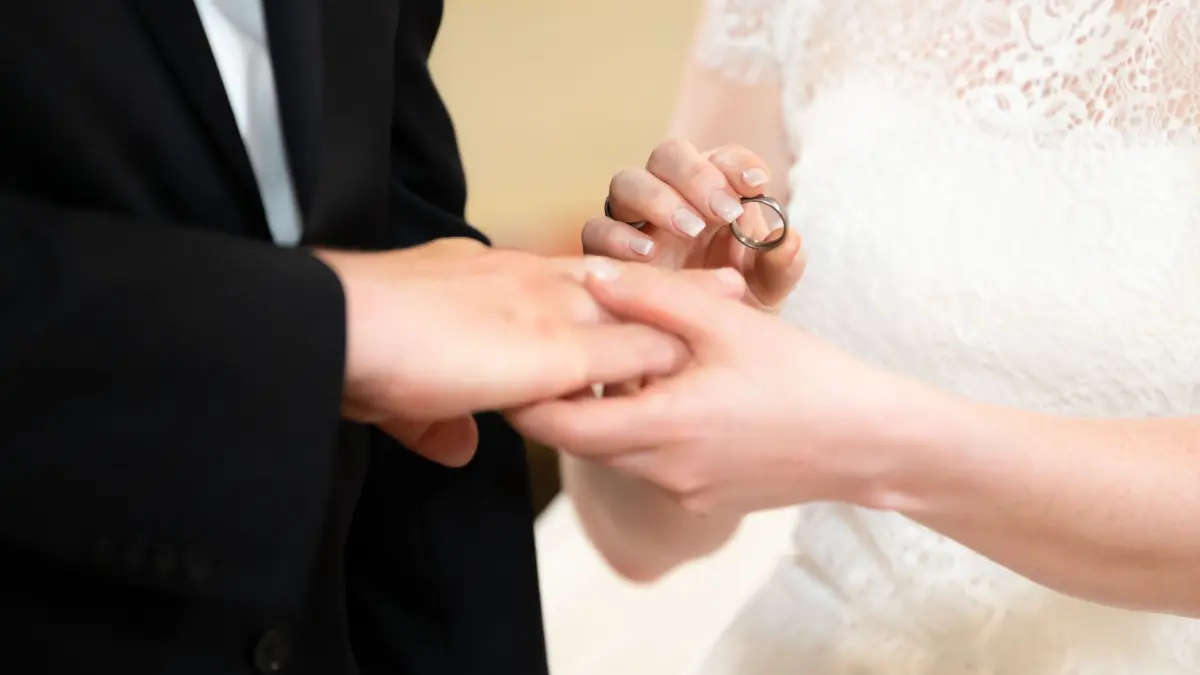 Symbolbild - Hochzeit: ARCHIV - 26.06.2021, Baden-Württemberg, Schiltach: Ein Brautpaar steckt sich während ihrer Trauung in der Kirche die Ringe an. (zu dpa: «Spontan vor den Altar: «Einfach heiraten» im Mai») Foto: Silas Stein/dpa +++ dpa-Bildfunk +++