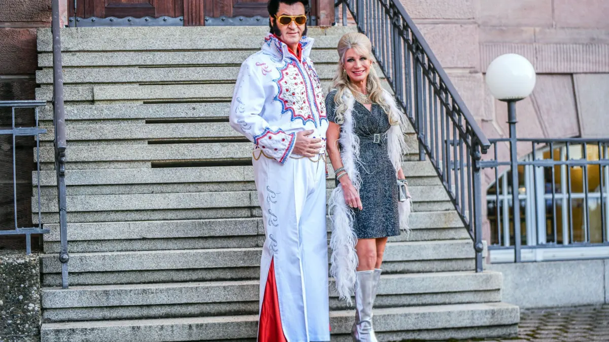 „Fastnacht in Franken“ - Markus Söder: 21.02.2025, Bayern, Nürnberg: Markus Söder (CSU, l), Ministerpräsident von Bayern, steht als Elvis Presley verkleidet neben seiner Frau Karin Baumüller-Söder. Söder nimmt an der Livesendung des Bayerischen Rundfunks «Fastnacht in Franken» in den Mainfrankensälen teil. Foto: Jason Tschepljakow/dpa +++ dpa-Bildfunk +++