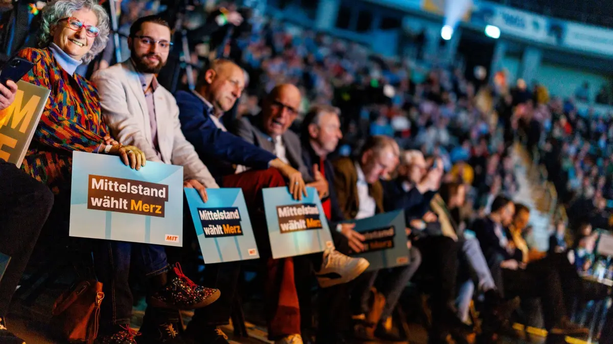 Wahlkampf CDU - Oberhausen: 21.02.2025, Nordrhein-Westfalen, Oberhausen: Zum Wahlkampfendspurt der CDU in Nordrhein-Westfalen sitzen Anhänger der Partei mit Plakaten in der Arena in Oberhausen. Foto: Christoph Reichwein/dpa - ACHTUNG: Nur zur redaktionellen Verwendung im Zusammenhang mit der aktuellen Berichterstattung über die Bundestagswahl 2025. Kein Archiv. +++ dpa-Bildfunk +++