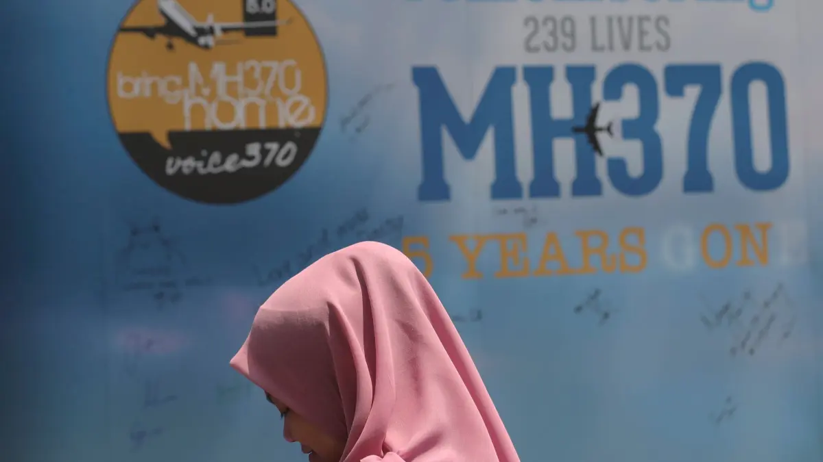 Verschwinden von Flug MH370: ARCHIV - 03.03.2019, Malaysia, Kuala Lumpur: Ein Mädchen steht während eines Gedenktages für das verschwundene Flugzeug MH370 vor einer Kondolenztafel. Im Indischen Ozean hat fast elf Jahre nach dem mysteriösen Verschwinden des Fluges MH370 der Malaysia Airlines eine neue Suchaktion nach dem Wrack begonnen. Die Spezialfirma Ocean Infinity will in den nächsten Wochen mit Hilfe des Tiefsee-Versorgungsschiffs Armada 7806 und autonomen Unterwasserfahrzeugen (AUVs) den Meeresboden nach Spuren der vermissten Boeing 777 abzusuchen. (zu dpa: «Neue Suche nach Flug MH370 startet vor australischer Küste») Foto: Vincent Thian/AP/dpa +++ dpa-Bildfunk +++