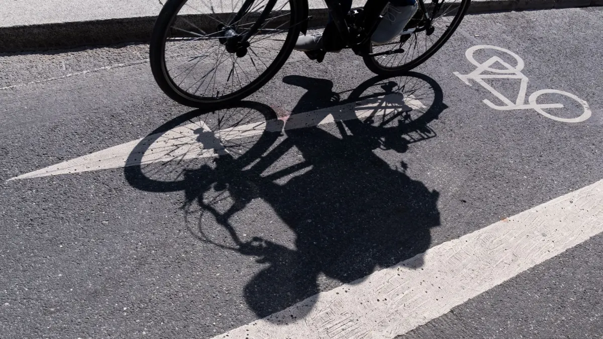 Fahrradweg mit Schatten: ARCHIV - 17.06.2019, Bayern, München: Ein Radfahrer wirft auf einem ausgewiesenen Radweg seinen Schatten. Die Stadt Mönchengladbach muss nach einem Gerichtsbeschluss einen geschützten Radfahrstreifen an einer Bundesstraße in der Innenstadt entfernen. (zu dpa: «Gericht: Stadt muss geschützten Radfahrstreifen entfernen») Foto: Peter Kneffel/dpa +++ dpa-Bildfunk +++