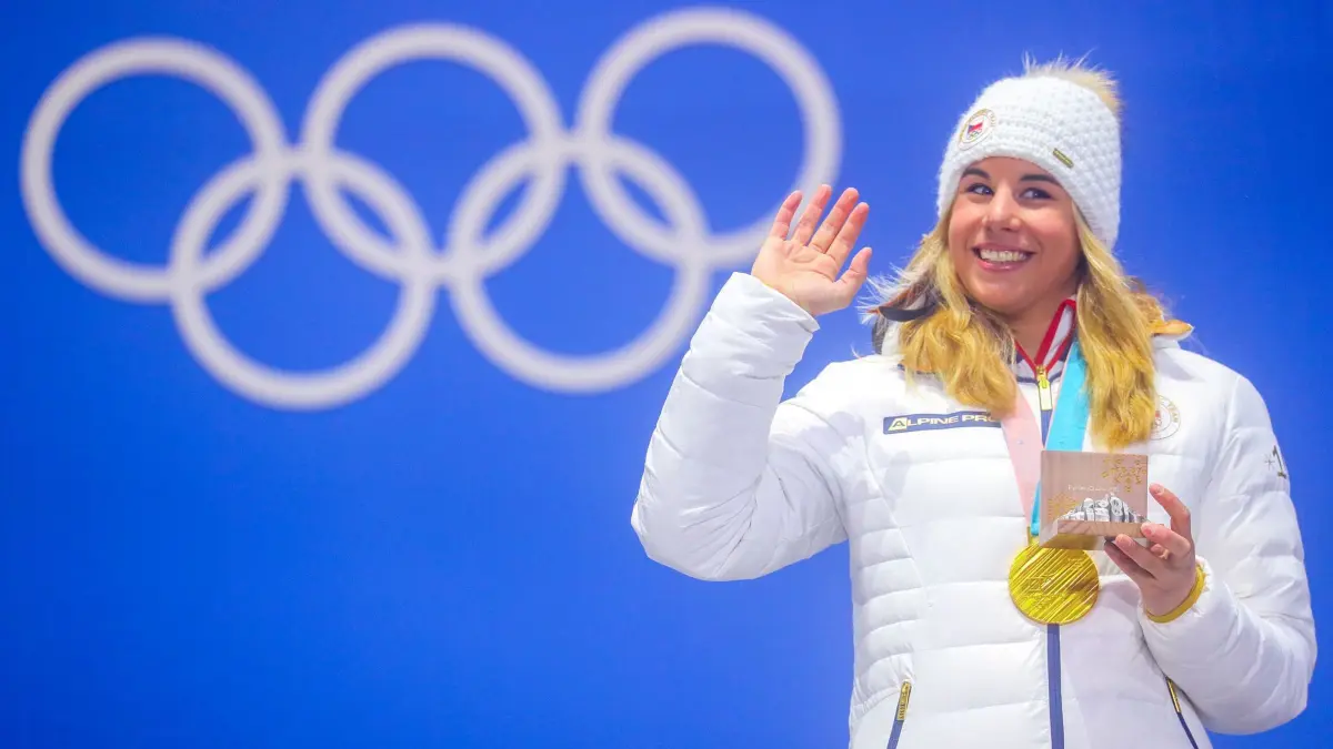 Ester Ledecka: ARCHIV - 24.02.2018, Südkorea, Pyeongchang: 24.02.2018, Südkorea, Pyeongchang, Olympia, Parallel-Riesenslalom, Damen, Siegerehrung Medal Plaza: Ester Ledecka, aus Tschechien zeigt ihre Goldmedaille. Sie kann 2026 nicht um Doppel-Gold auf Ski und auf dem Snowboard kämpfen. (zu dpa: «IOC bleibt hart: Keine Olympia-Ausnahme für Tschechen-Star») Foto: Michael Kappeler/dpa +++ dpa-Bildfunk +++