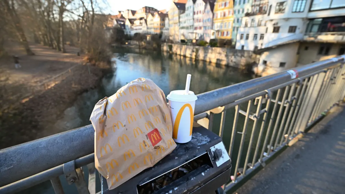 McDonald's: PRODUKTION - 21.01.2025, Baden-Württemberg, Karlsruhe: Eine McDonald's To-Go-Tüte und ein To-Go-Becher stehen auf einem Mülleimer auf der Neckarbrücke in Tübingen (gestellte Szene). Das Bundesverfassungsgericht entscheidet über die umstrittene Verpackungssteuer auf Einwegbecher und Essensverpackungen der Stadt Tübingen. (zu dpa: «Freiburger Verwaltung will Mehrweg statt Verpackungssteuer») Foto: Bernd Weißbrod/dpa +++ dpa-Bildfunk +++