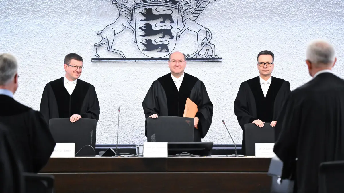 Gericht entscheidet über Volksbegehren gegen XXL-Landtag: 28.02.2025, Baden-Württemberg, Stuttgart: Die Richter Christian Seiler (l-r), Malte Graßhof (Präsident) und Daniel O'Sullivan vom Verfassungsgerichtshof stehen in einem Gerichtssaal vor der Verkündung einer Entscheidung über die Zulassung eines Volksbegehrens gegen die drohende Aufblähung des Landtags. Die FDP befürchtet einen übergroßen Landtag. Das Innenministerium lehnte ein Volksbegehren ab, welches das Aufblähen verhindern sollte. Deshalb zogen die Liberalen vor das Verfassungsgericht des Landes. Foto: Bernd Weißbrod/dpa +++ dpa-Bildfunk +++