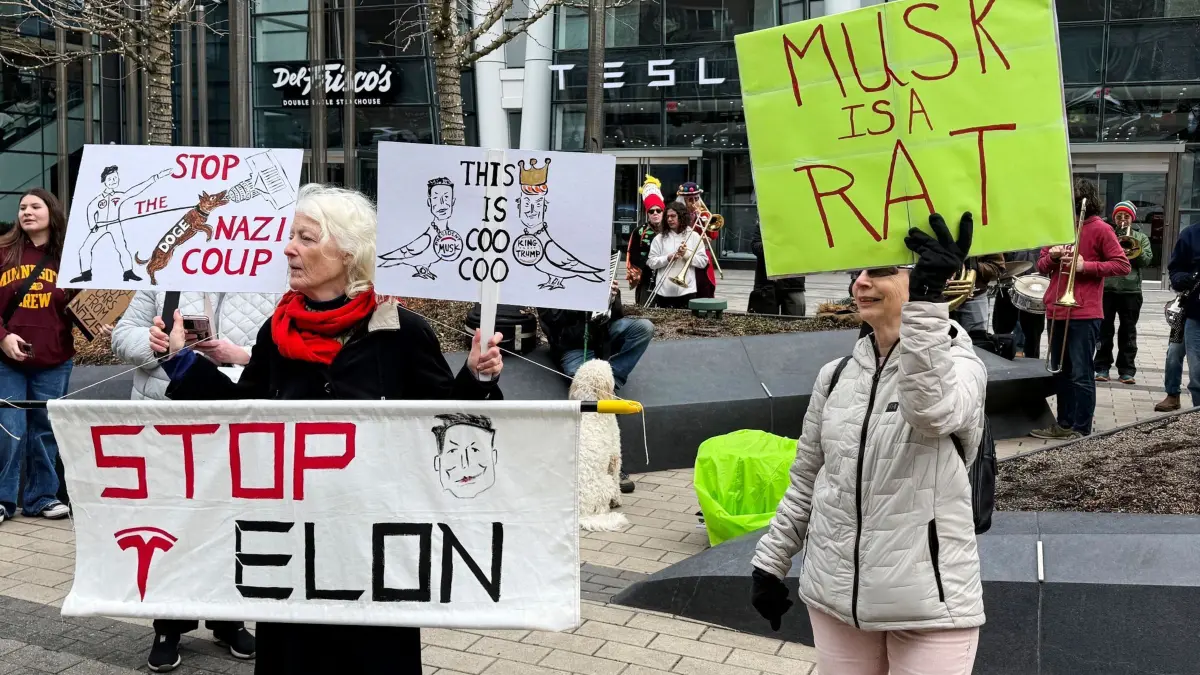 Protest gegen Musk und Tesla in Boston: 01.03.2025, USA, Boston: Demonstranten demonstrieren vor einem Tesla-Geschäft in Boston gegen Musk, den Vorstandsvorsitzenden des Unternehmens, der sich im Namen von US-Präsident Trump für den Abbau von Arbeitsplätzen in der Regierung einsetzt. Foto: Rodrique Ngowi/AP/dpa +++ dpa-Bildfunk +++