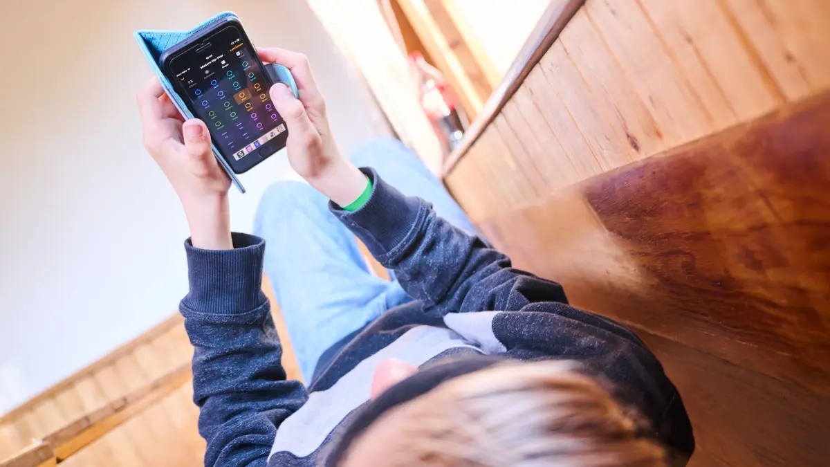 Kinder in der digitalen Welt: ARCHIV - 28.05.2022, Berlin: Ein Junge liegt auf einer Bank und spielt auf seinem Handy ein Online-Spiel. (zu dpa: «Eltern haben Handy-Verbot in Kitas akzeptiert») Foto: Annette Riedl/dpa +++ dpa-Bildfunk +++