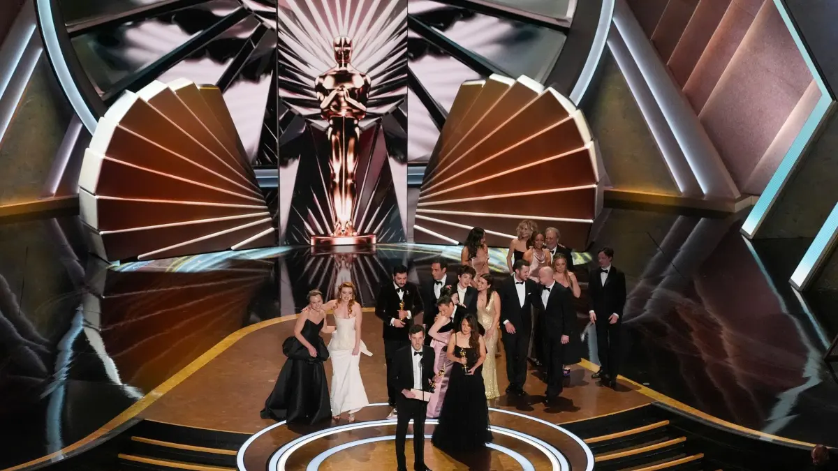 97. Academy Awards: 02.03.2025, USA, Los Angeles: Daria Ekamasova, von links, Lindsey Normington, Vache Tovmasyan, Karren Karagulian, Alex Coco, vorne links, Samantha Quan, vorne rechts, Mikey Madison, Sean Baker, Mark Eydelshteyn und Yura Borisov nehmen den Preis für den besten Film für "Anora" während der Oscar-Verleihung im Dolby Theatre in Los Angeles entgegen. Meg Ryan und Billy Crystal sehen von hinten rechts auf der Bühne zu. Foto: Chris Pizzello/Invision/dpa +++ dpa-Bildfunk +++