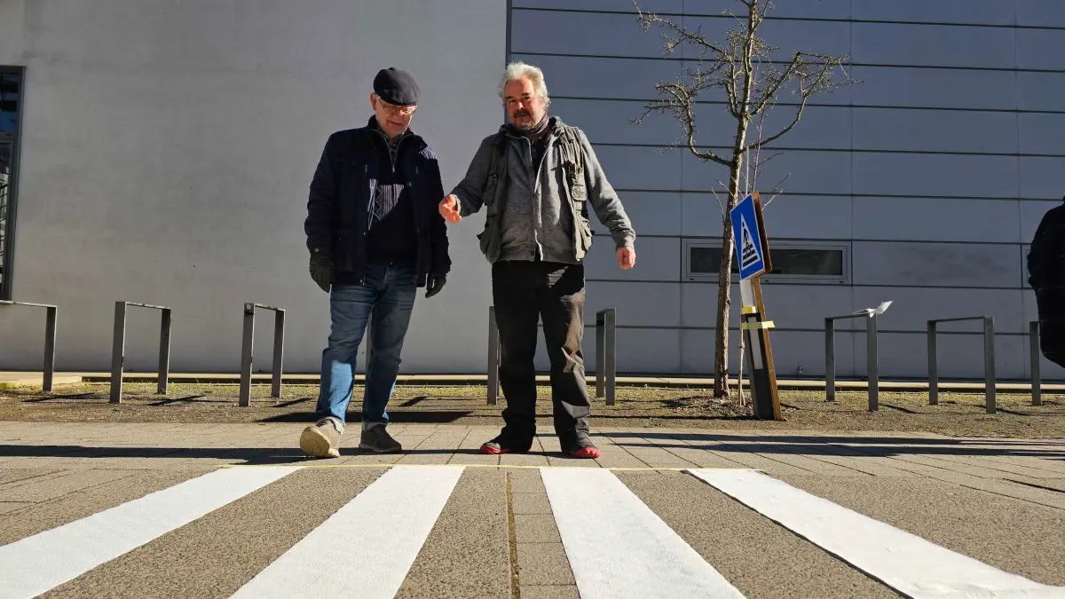 Gedrehter Zebrastreifen: 03.03.2025, Thüringen, Erfurt: Der Erfurter Ortsteilbürgermeister Robert Bednarsky und der Dozent der Fachhochschule Erfurt StefanPeter Andres sprechen über die Vorteile eines Zebrastreifens mit um 90 Grad gedrehten Streifen. (zu dpa: «Besser gedreht? Initiative für Zebrastreifen-Design») Foto: Tobias Junghannß/dpa +++ dpa-Bildfunk +++