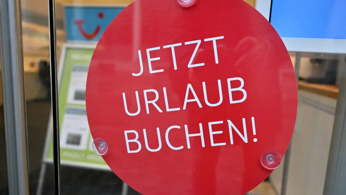 Reisebüro: ARCHIV - 28.12.2021, Bayern, München: Ein Schild mit der Aufschrift «Jetzt Urlaub buchen!» hängt in einem Reisebüro in der Innenstadt. Die Reisewirtschaft in Deutschland ist auf Kurs zum Umsatzniveau des Vor-Corona-Jahres 2019. (zu dpa: «Reisebüros im Wandel: Digitalisierung und Expertise im Fokus») Foto: Peter Kneffel/dpa +++ dpa-Bildfunk +++