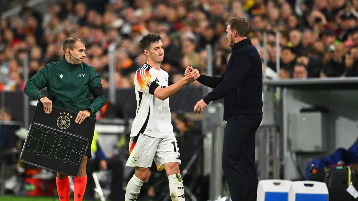 Fußball-Nationalmannschaft: ARCHIV - 14.10.2024, Bayern, München: Fußball, Nations League A, Deutschland - Niederlande, Gruppenphase, Gruppe 3, 4. Spieltag, Allianz Arena, Deutschlands Angelo Stiller (l) klatscht nach seiner Auswechslung mit Bundestrainer Julian Nagelsmann ab. (zu dpa: «Nagelsmann ärgert Liga-Ansetzung vor Italien-Kracher») Foto: Tom Weller/dpa +++ dpa-Bildfunk +++