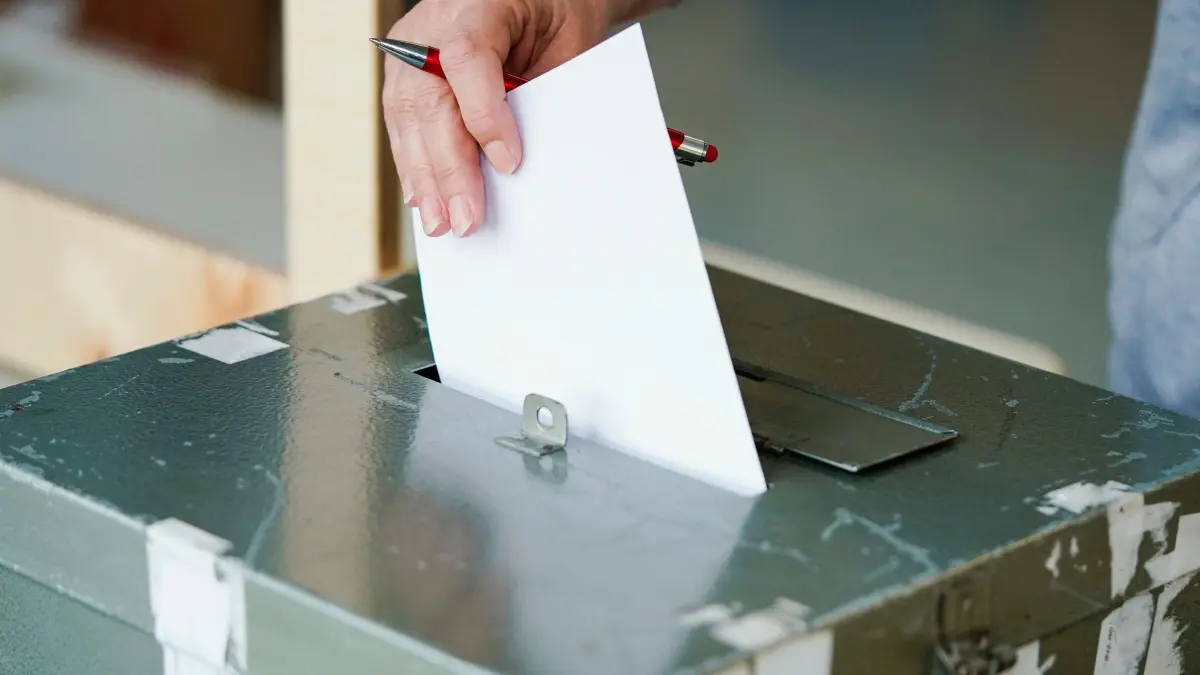 Landtagswahl in Baden-Württemberg: ARCHIV - 14.03.2021, Baden-Württemberg, Mannheim: Ein Wählerin wirft in einem Wahllokal in der Wallstadtschule ihren Stimmzettel in die Wahlurne. Das Wahlrecht soll mit Hilfe eine Volksbegehrens in Baden-Württemberg geändert werden. (zu dpa: «Strobl schlägt 8. März als Termin für Landtagswahl 2026 vor») Foto: Uwe Anspach/dpa +++ dpa-Bildfunk +++