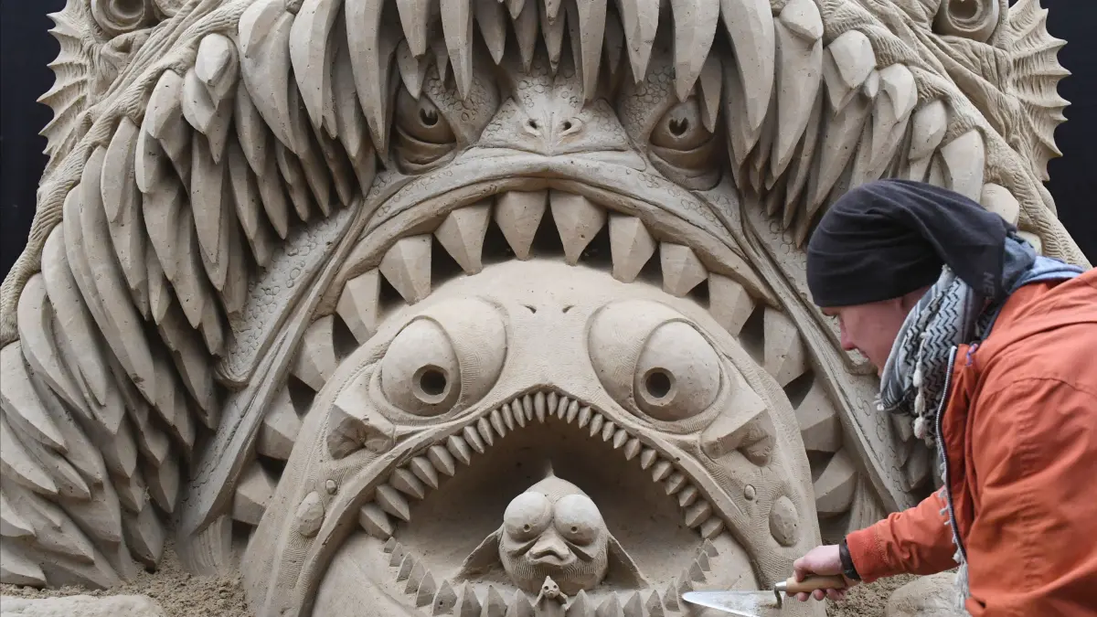 dpatopbilder - Der Bildhauer Donatan Mockus aus Litauen arbeitet am 08.04.2017 auf dem Gelände des jährlichen Sandskulpturenfestivals in Ahlbeck auf der Insel Usedom (Mecklenburg-Vorpommern) an einer Monsterfischskulptur zum Thema Tiefsee. In diesem Jahr stehen «Maritime Abenteuer» im Mittelpunkt der Ausstellung. Auf dem Rundgang durch die weltweit größte Sandskulpturen-Ausstellung entdeckt der Besucher die Wunderwelt Meer in einer einzigartigen Form. Bis zum 05.11.2017 sind die Sandskulpturen auf der Insel Usedoym zu sehen. Foto: Stefan Sauer/dpa-Zentralbild/dpa ++ +++ dpa-Bildfunk +++