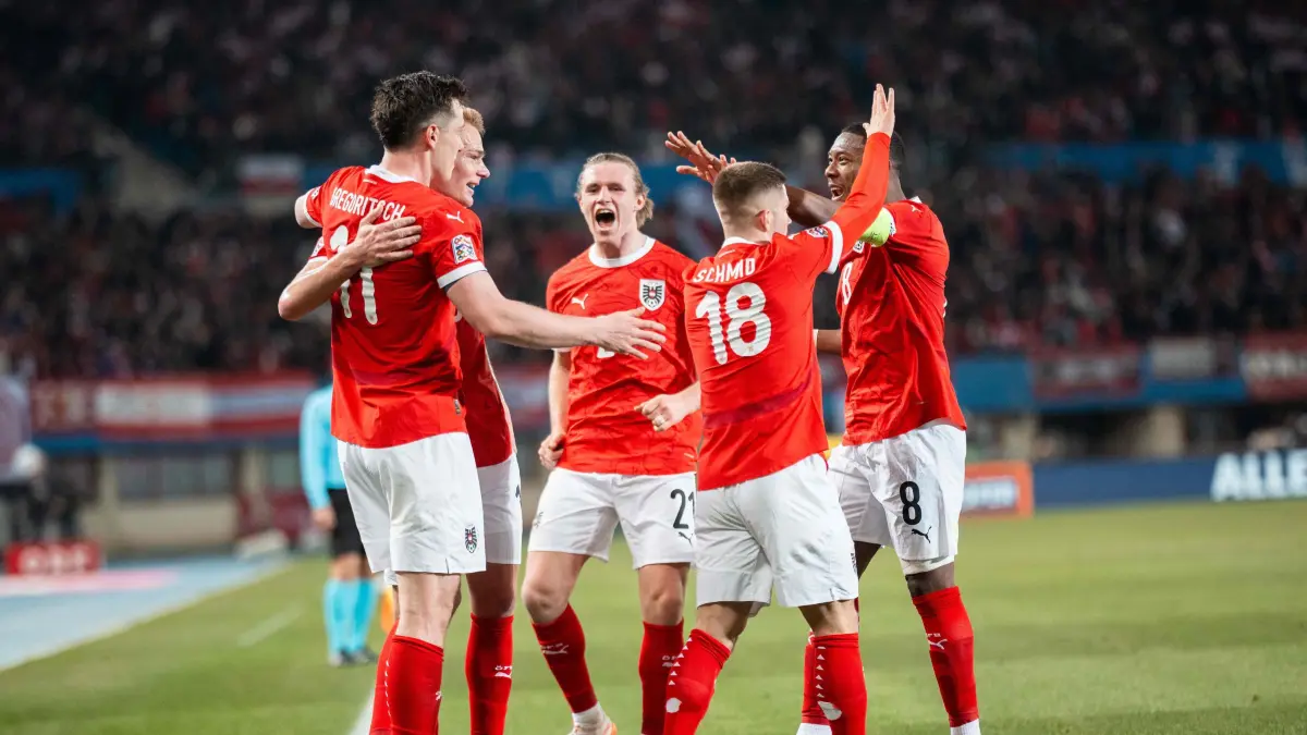 Austria's forward #11 Michael Gregoritsch (L) celebrates with teammates scoring the opening goal during the UEFA Nations League play-off, first-leg football match Austria v Serbia at the Ernst Happel Stadium in Vienna on March 20, 2025. (Photo by GEORG HOCHMUTH / APA / AFP) / Austria OUT