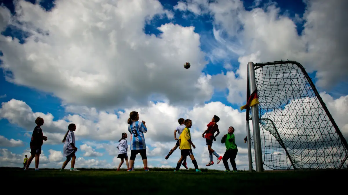 Amateur- und Jugendfußball: ARCHIV - 12.06.2014, Niedersachsen, Neustadt am Rübenberge: Kinder spielen auf dem Testgelände des Bundessortenamt - Prüfstelle Scharnhorst Fußball. (zu dpa: «Studie: Jugendliche seit Corona weniger ausdauernd») Foto: Julian Stratenschulte/dpa +++ dpa-Bildfunk +++