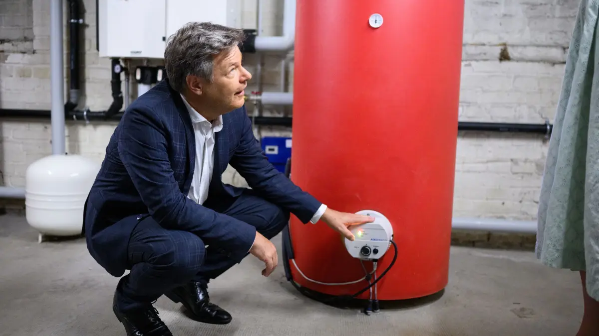 Minister Habeck: ARCHIV - 15.07.2024, Berlin: Robert Habeck (Bündnis 90/Die Grünen), Bundesminister für Wirtschaft und Klimaschutz, unterhält sich bei der Besichtigung eines "Power-to-Heat" ("Strom zu Wärme") Pilotprojekts für die Mehrfamilienhäuser des Wohnungsunternehmens Vonovia in einem Heizungskeller. (zu dpa: «Koalitions-Unterhändler für Kurswechsel beim Heizungsgesetz») Foto: Bernd von Jutrczenka/dpa +++ dpa-Bildfunk +++