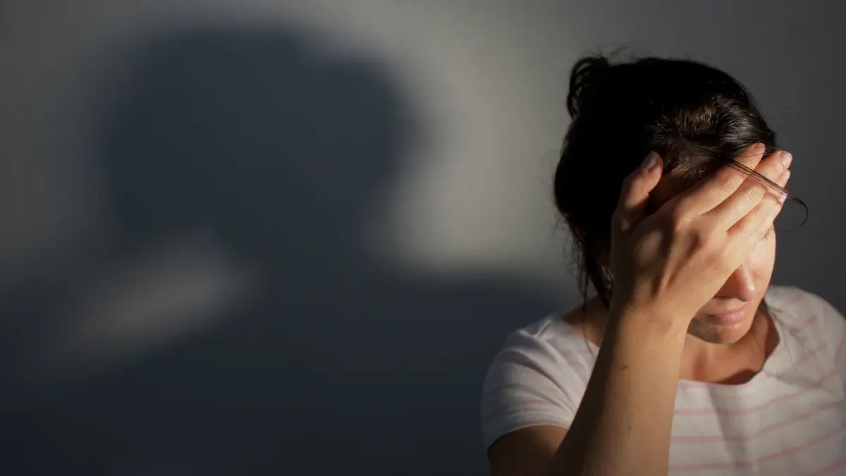 Frau fasst sich an die Stirn: ILLUSTRATION - Komplette Reizüberflutung? Ob eine Autismus-Spektrum-Störung dahintersteckt, können Fachärzte für Psychotherapie oder Psychotherapeuten feststellen. (zu dpa: «Autismus? Was die Diagnose im Erwachsenenalter bringt») Foto: Oliver Killig/dpa/dpa-tmn - Honorarfrei nur für Bezieher des dpa-Themendienstes +++ dpa-Themendienst +++
