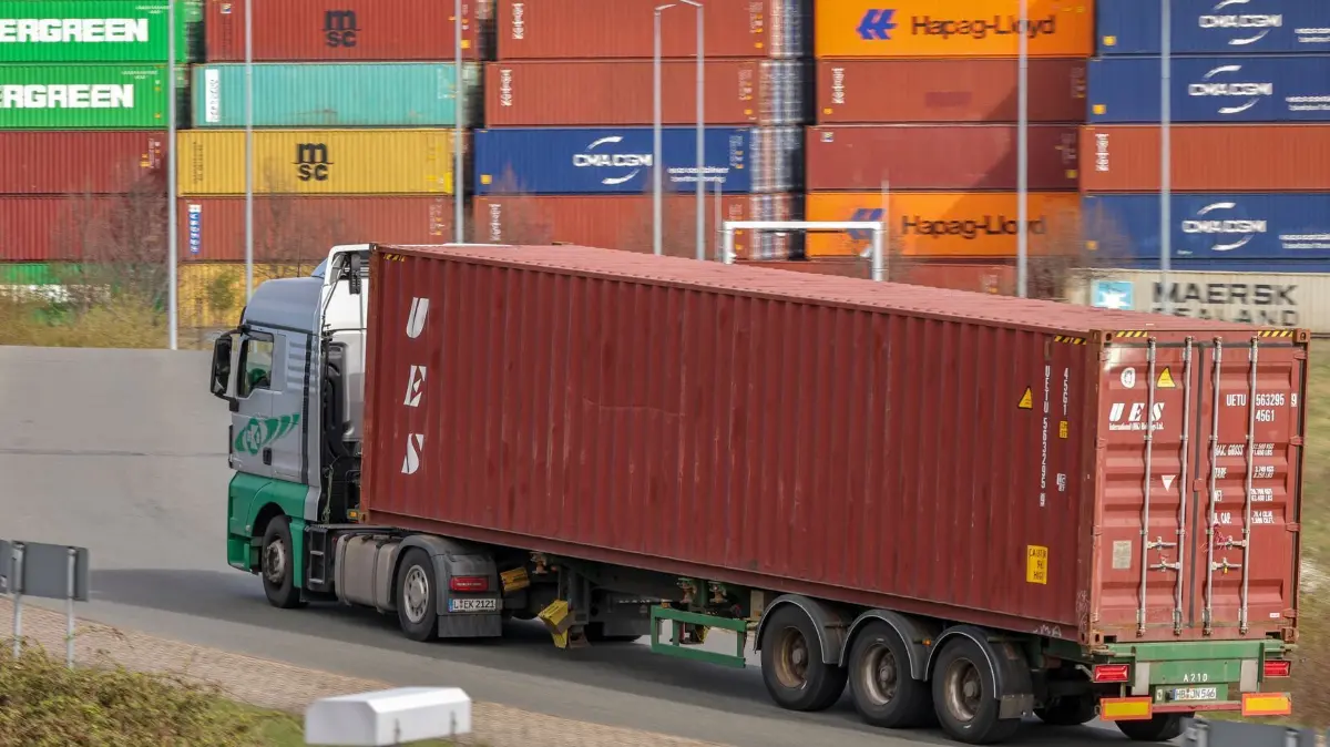Zollkonflikt mit den USA - Umschlagbahnhof Leipzig: 07.04.2025, Sachsen, Leipzig: Ein Lkw mit Container fährt nach dem Beladen aus dem DUSS-Terminal Leipzig-Wahren. Im Zollkonflikt mit den USA berät die EU über ihre Strategie. Foto: Jan Woitas/dpa +++ dpa-Bildfunk +++