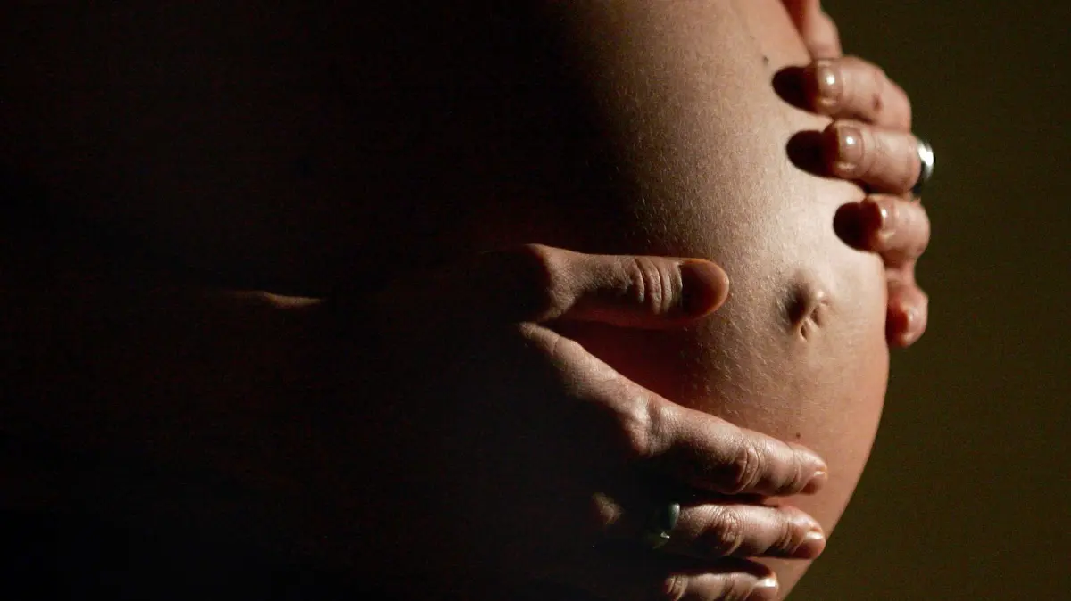 Schwangere: ARCHIV - 08.01.2007, Nordrhein-Westfalen, Bonn: Eine hochschwangere Frau fasst sich mit beiden Händen an ihren Bauch. Weltweit sterben jedes Jahr etwa 4,5 Millionen Mütter und Babys während der Schwangerschaft, bei der Geburt oder in den ersten Lebenswochen. (zu dpa: «Banner in türkischem Stadion zu «natürlicher Geburt» sorgt für Kritik») Foto: Felix Heyder/dpa +++ dpa-Bildfunk +++
