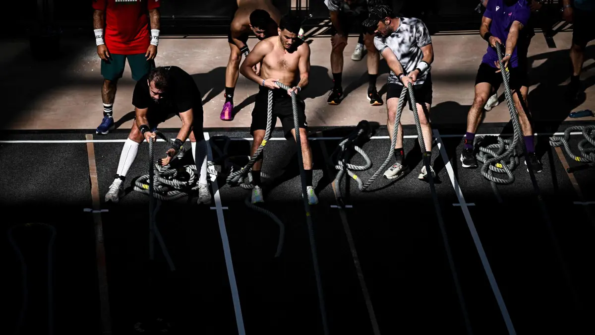 Participants compete in the "Sled pull" event during the Hyrox fitness race at the Grand Palais venue in Paris, on April 18, 2025. (Photo by JULIEN DE ROSA / AFP)